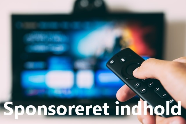 Mand holder fjernbetjening i hånden foran slørret tv i baggrunden